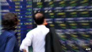 Investors looking at market board on Tokyo