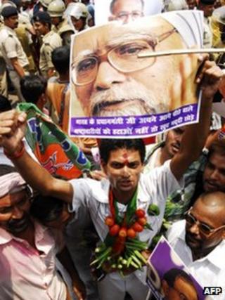 Сторонник оппозиции Индии Национальный демократический альянс держит плакат премьер-министра Индии Манмохана Сингха держит плакат во время митинга в Патне 31 мая 2012 года,