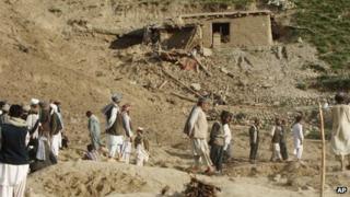 Афганцы стоят на месте происшествия после землетрясения в провинции Баглан, к северу от Кабула, Афганистан, понедельник, 11 июня 2012 г.