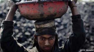 Молодой мальчик, перевозящий уголь на шахте в Индии