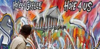 Man walking past Athens graffiti