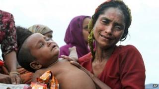 A Rohingya Muslim woman holds her baby on board that has been intercepted as it approached Bangladesh.