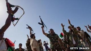 Libyan rebel soldiers from Bengazi celebrate as they arrive on an ex-Libyan Army frigate on August 30, 2011 in Tripoli, Libya