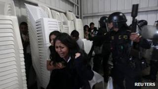 Protesters hide from riot police at clashes in Guatemala