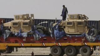 A driver stands on top of a truck carrying Nato Humvees at a terminal in the Pakistani-Afghan border, in Chaman, Pakistan, Wednesday, July 4, 2012.
