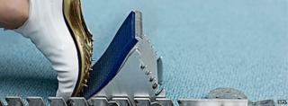 Running shoe with spikes in starting block (Science Photo Library)