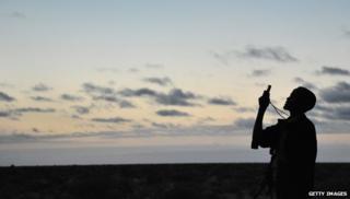 An African man holds up his mobile to get signal