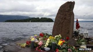 Flowers and candles are placed on the shore opposite to the Utoeya Island, Norway, Sunday, July 24, 2011