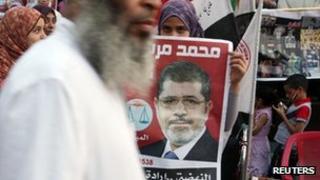A supporter holds a poster of Egypt's President Mohammed Mursi at Tahrir Square in Cairo 10 July