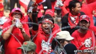 Red Shirt supporters of former PM Thaksin Shinawatra chant slogans at a television satellite centre on April 09, 2010 in Bangkok,Thailand.