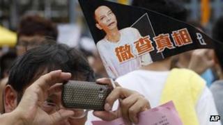 A man holding a flag with picture of Chinese activist Li Wangyang during a pro-democracy protest march in Hong Kong, 1 July, 2012