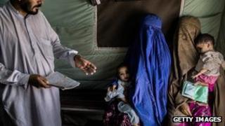их матери ждут, чтобы пройти вакцинацию против полиомиелита в клинике «Мерлин» в лагере УВКБ ООН в Джалозай для
