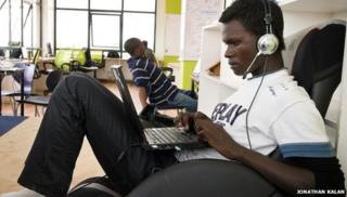 Мужчина пользуется ноутбуком на iHub в Кении
