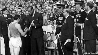 Кен Джонс вручает эстафету с посланием королевы герцогу Эдинбургскому на церемонии открытия Британской империи и Игр Содружества, Парк Кардифф Армс, 1958 год. ИСПОЛЬЗОВАНИЕ ТОЛЬКО СОГЛАСОВАНО С РОБОМ НОРМАНОМ