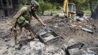Индийский солдат ищет тела подозреваемых боевиков в руинах дома после перестрелки в Бабане, в 90 км (55 миль) к северу от Сринагара
