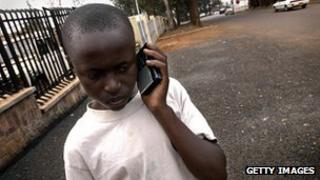 Руандийский мальчик слушает портативное радио