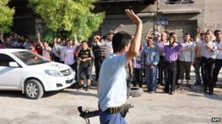 Syrian rebel in northern Aleppo salutes residents chanting anti-government slogans (26 July)