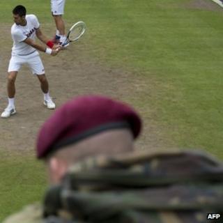Soldier watching Novak Djokovic practice at Wimbledon