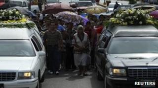 People walk in a funeral cortege in Muzquiz, Mexico