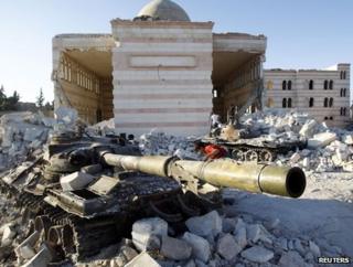 A boy plays on a tank near a ruined mosque in Azaz, 47km (29 miles) north of Aleppo, 3 August