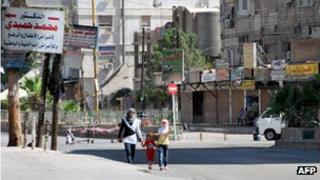 Girls walk down the street in the deserted neighbourhood of Sayyida Zeinab on the southern outskirts of the the Syrian capital, Damascus, on 29 July