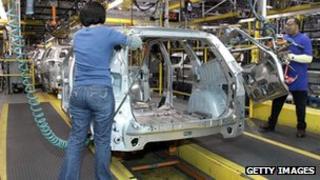 Workers build a GM crossover SUV as it goes through the assembly line at the General Motors