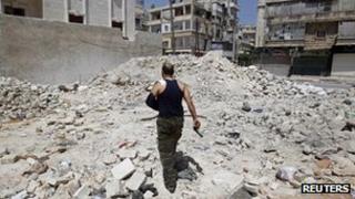A wounded Free Syrian Army commander walks through rubble in the Salah al-Din neighbourhood of central Aleppo, Syria, on Saturday