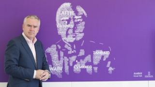 Huw Edwards, mab Hywel teifi Edwards, o flaen y murlun yn yr Eisteddfod ddydd Gwener