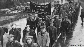 Unemployed men on a hunger march pass through a British town, circa 1935.