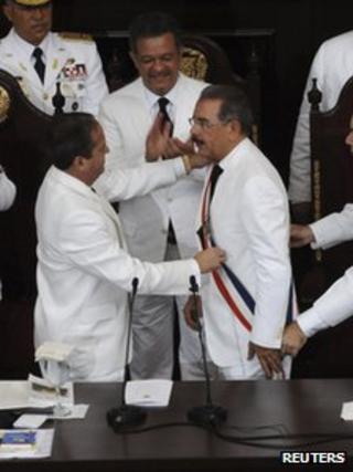 Dominican Republic's President Danilo Medina (R) receives the presidential sash from by the Senate's President Reinaldo Pared Perez