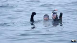French amputee swimmer Philippe Croizon (R), and his friend swimmer Arnaud Chassery, celebrate after swimming between islands in the icy Bering Strait on 18 August 2012