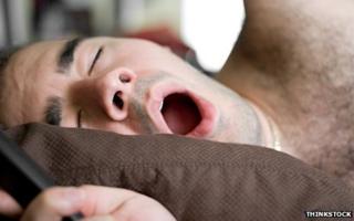 Человек зевает в постели