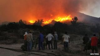Residents watch a forest fire in the village of Kalamoti in the Greek island of Chios (19 August 2012)