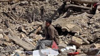 A man sits amid rubble near the village of Varzaqan in Iran's northwest Tabriz province on 11 August 2012
