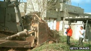 Rachel Corrie stands between an Israeli bulldozer and a Palestinian house on 16 March 2003 in the Rafah refugee camp in the Gaza Strip on 16 March 2003