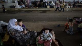 A Syrian family who fled their home take refuge at the Bab Al-Salameh border crossing with Turkey near the Syrian town of Azaz, 29 August 2012