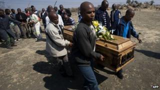 A group of men carry the coffin of a miner killed during the strike