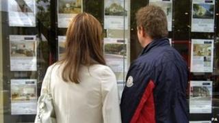 Couple looking in estate agent window
