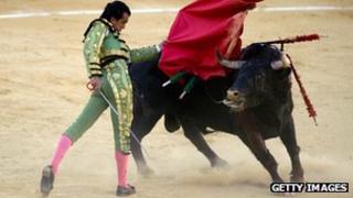 Испанский матадор Леандро Маркос Висенте выполняет пас во время боя быков в арены для боя быков в Малаге 13 августа 2012 года
