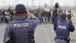 Police try to prevent striking mine workers marching to the Karee shaft at the Lonmin Platinum Mine near Rustenburg, South Africa Wednesday, Sept, 5, 2012