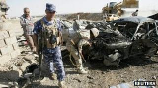 Security personnel inspect the site of a bomb attack in Kirkuk