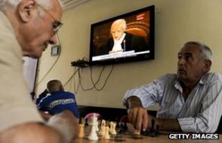 Men play chess and watch TV, Pristina, 2010