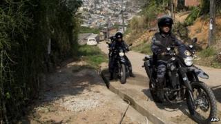 Police on motorbikes patrol the Chatuba favela