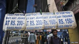 Люди покупают одежду на придорожном рынке в Калькутте 15 сентября 2012 года