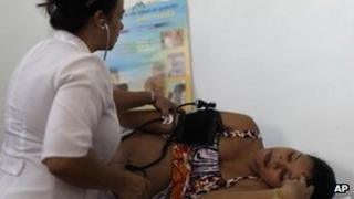 A nurse checks the blood pressure of patient Niurka Rodriguez, who is eight months pregnant at a government run neighbourhood clinic in Havana