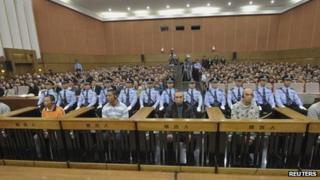 Suspects involved in murders of 13 Chinese sailors on the Mekong River are on trial as police officers sit guard behind them at a court in Kunming, 20 Sept 2012