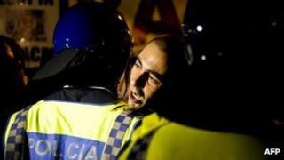 A protester is held back by police outside the presidential palace