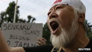Мужчина выкрикивает лозунги на антикитайском митинге в Токио, 22 сентября