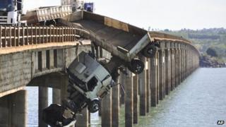 A truck hangs from the Chavantes bridge near Fartura, southern Brazil, Saturday, Sept. 22, 2012. The driver survived uninjured.
