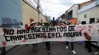 Members of the Peasant Unified Movement (MUCA) of Bajo Aguan, carry mock coffins bearing pictures of murdered mates in land conflict clashes. Sep 15 2012.